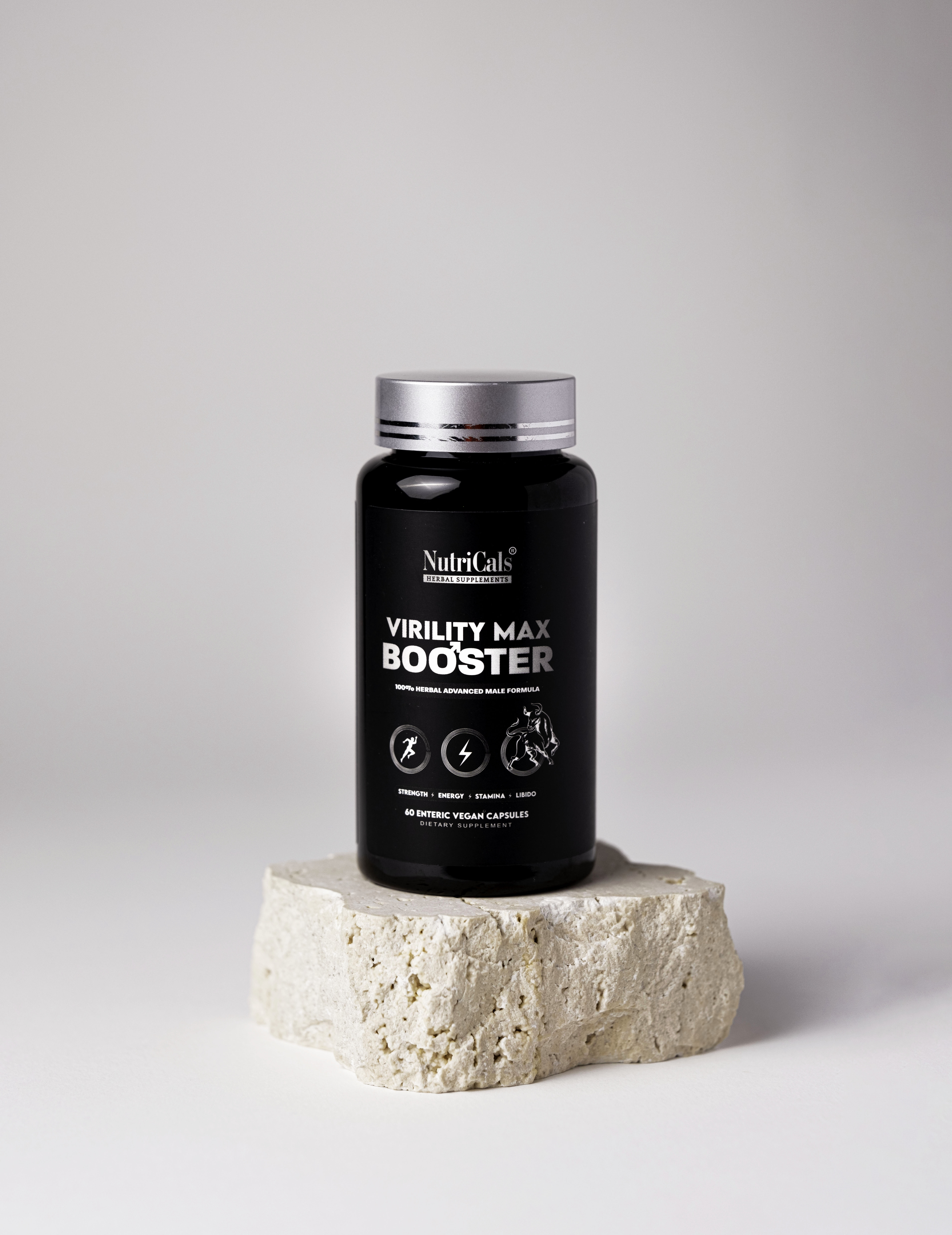 Virility Max Booster bottle on travertine stone surface, front label visible.